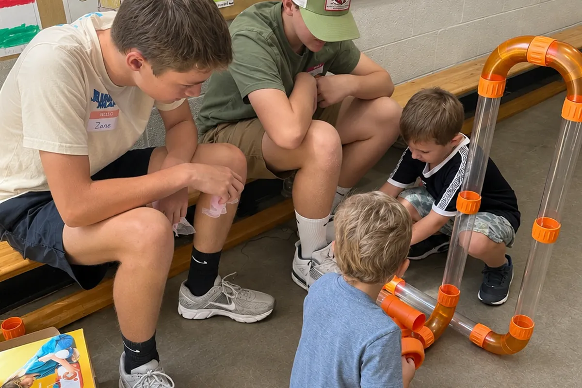 Summit preschool students collaborating with older students during a hands-on activity