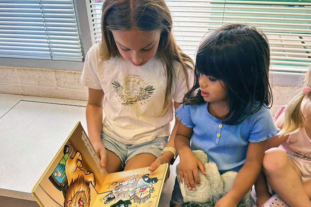 Summit preschool student sharing a book with an older student