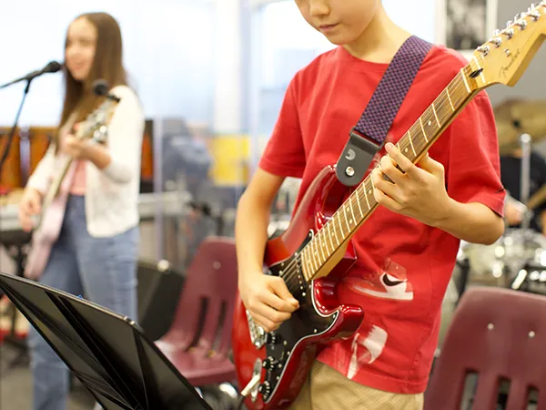 summit-school-ahwatukee-student-music-guitar Summit School student playing electric guitar during music class.