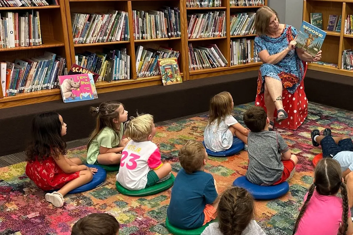 summit-elementary-library-storytime Elementary students listening to a story during library class at Summit School.