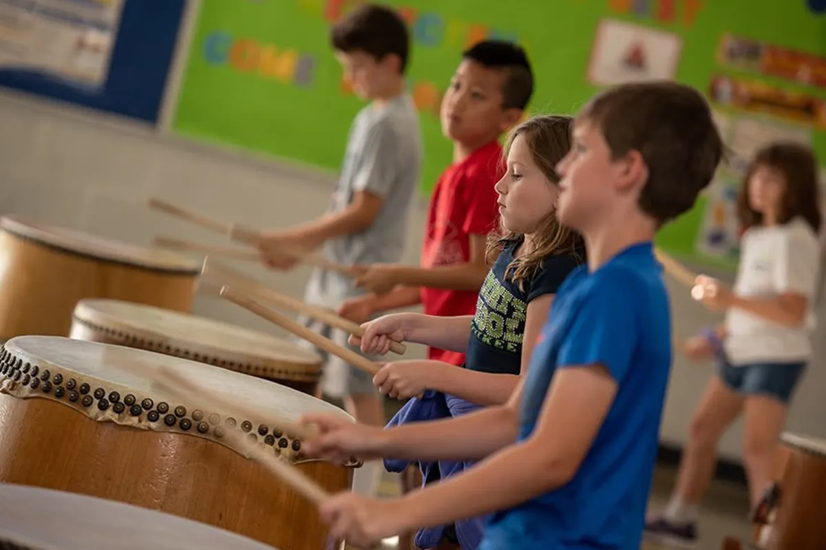 summit-elementary-music-taiko-drumming Elementary students playing taiko drums during music class at Summit School.