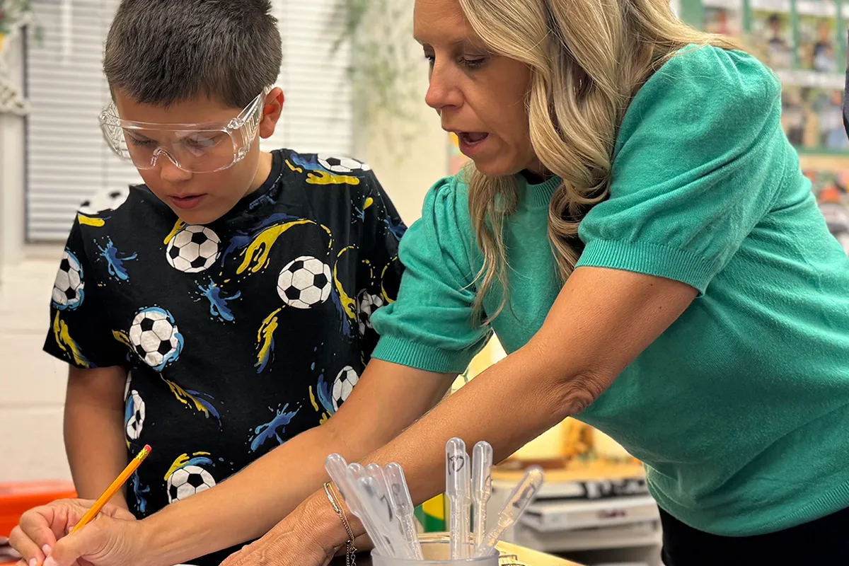 Summit middle school teacher providing individualized support to a student during class.