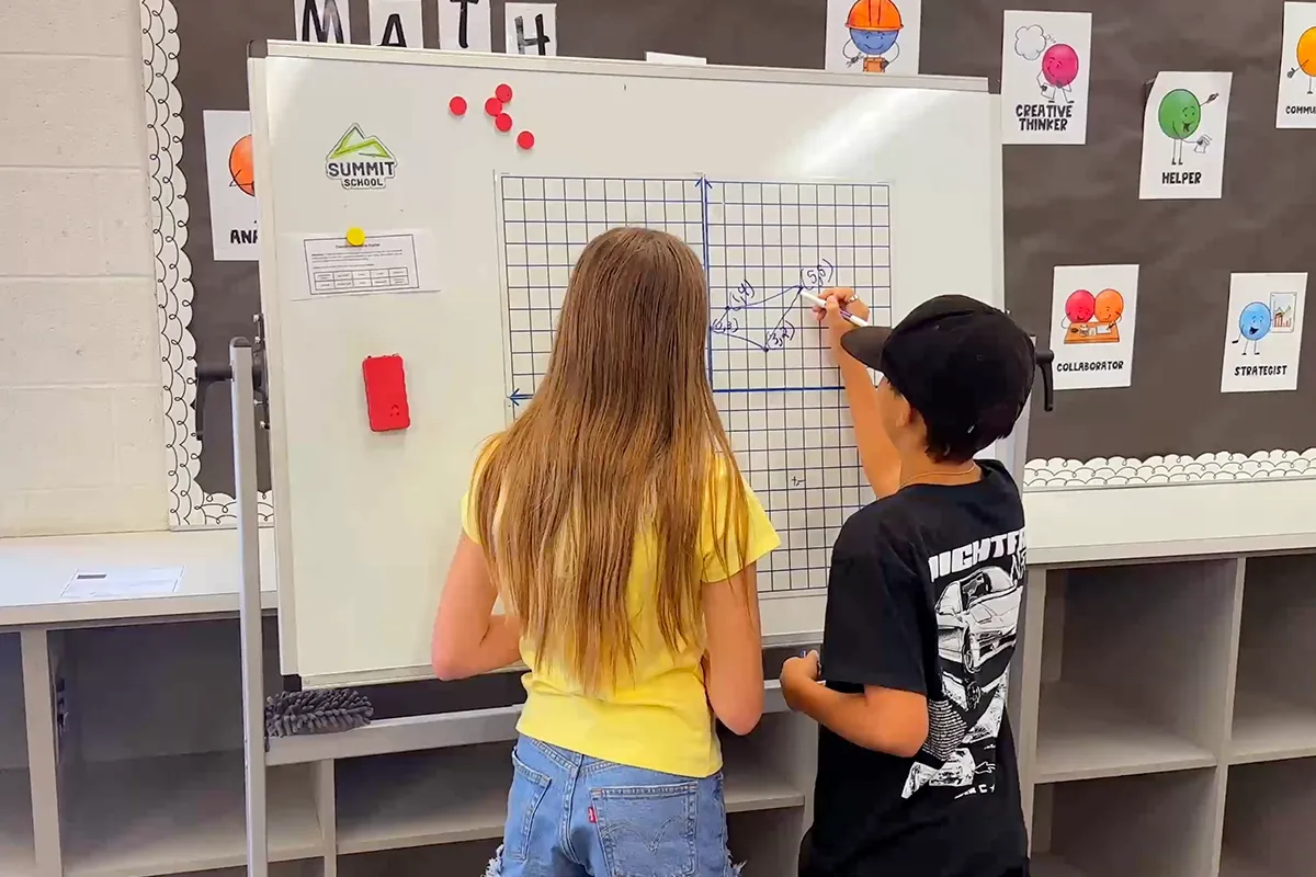 Summit middle school students working together on a coordinate graph in math class.