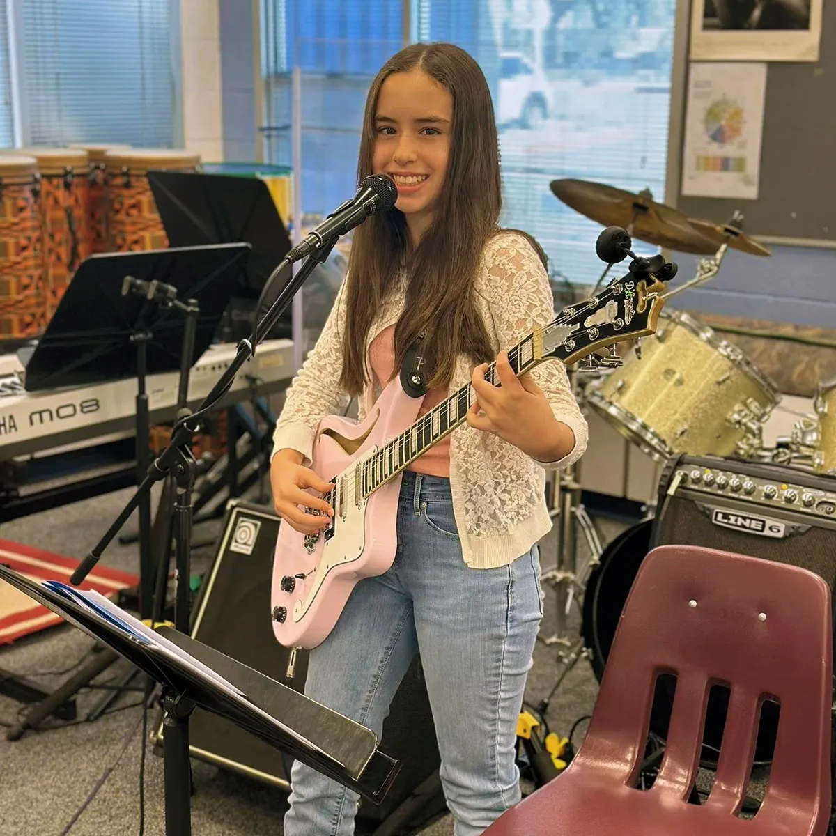 summit-middle-school-rock-band-elective Summit Middle School student singing and playing electric guitar during a rock band elective.