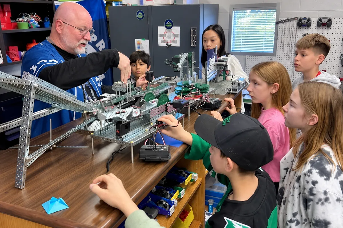 summit-middle-school-stem-robotics-elective ummit Middle School students working with a teacher on a robotics project.