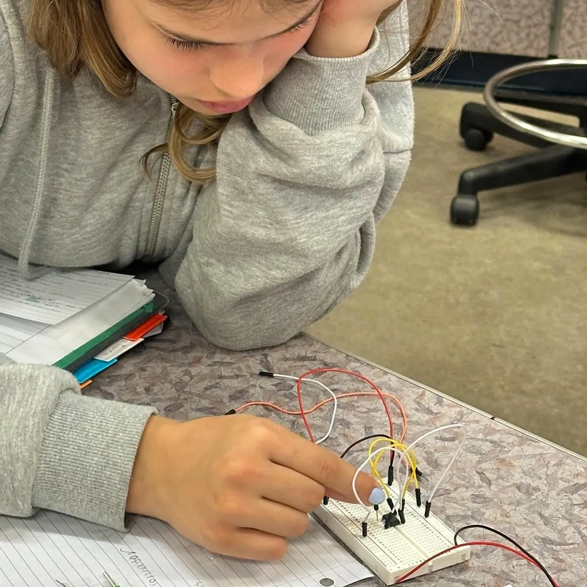 Summit middle school student testing an electrical circuit during a project-based learning activity.