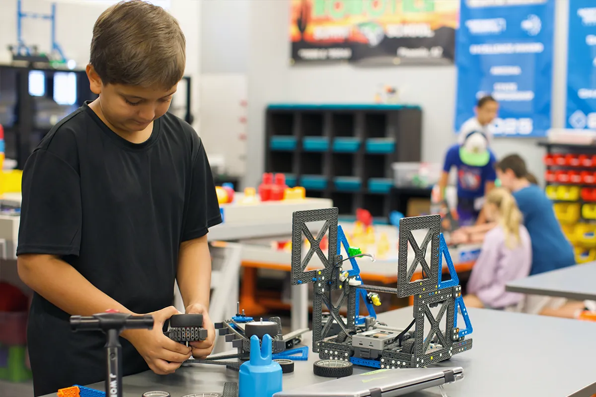 summit-middle-school-student-robotics-engineering Summit middle school student building and testing a robotics project.