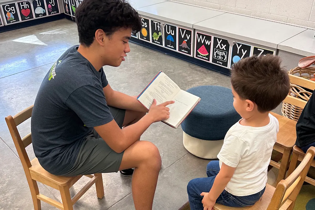 summit-school-cross-age-student-mentoring Older Summit student reading with a younger student during a cross-age activity.