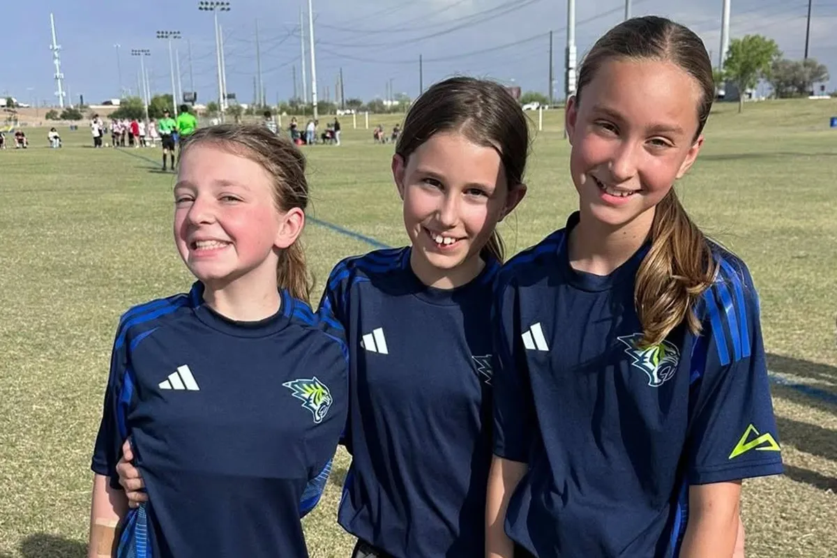 summit-school-girls-soccer-team Three Summit girls soccer players together on the field.