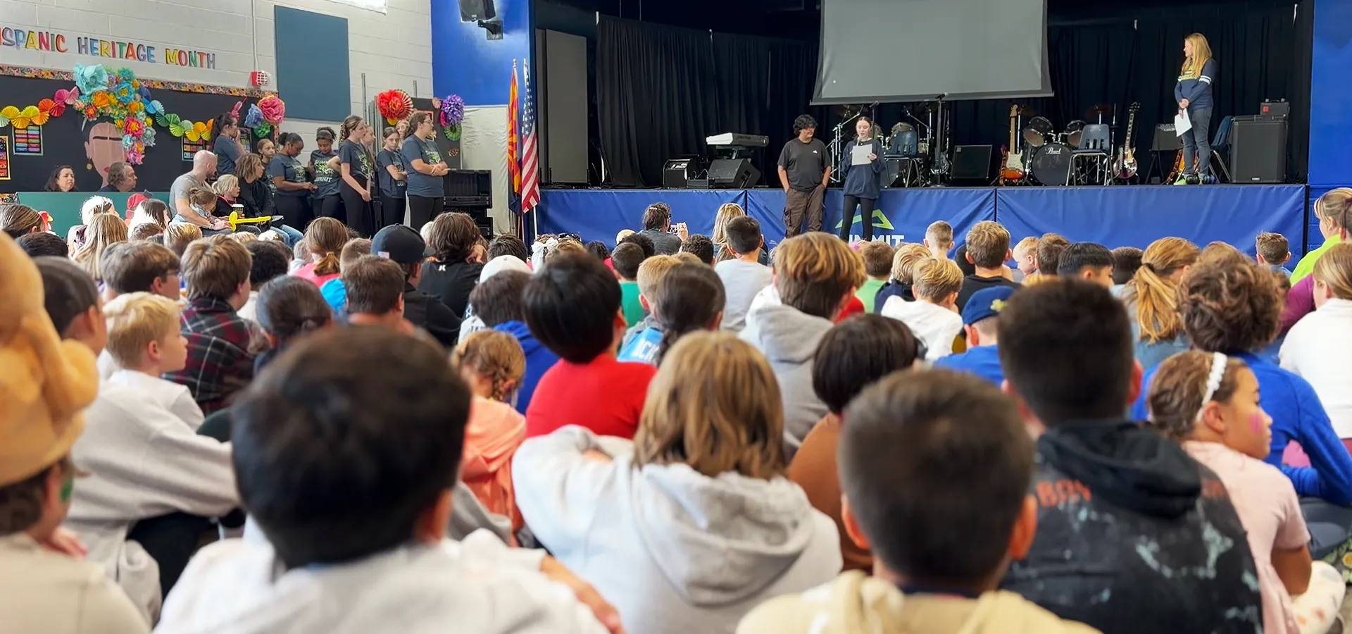 summit-school-morning-meeting-community-assembly Summit School students gathered for Morning Meeting as students present on stage to the school community.