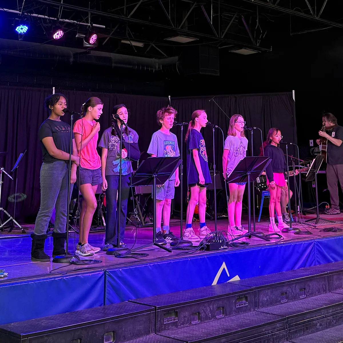 summit-school-morning-meeting-student-vocal-performance Summit School students sing together on stage during a Morning Meeting performance.