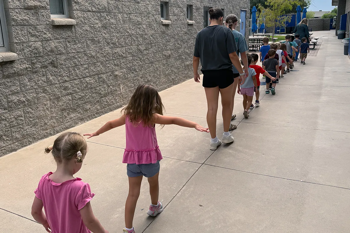 summit-school-morning-meeting-students-connect-across-grades Younger Summit School students walk with older students to Morning Meeting.