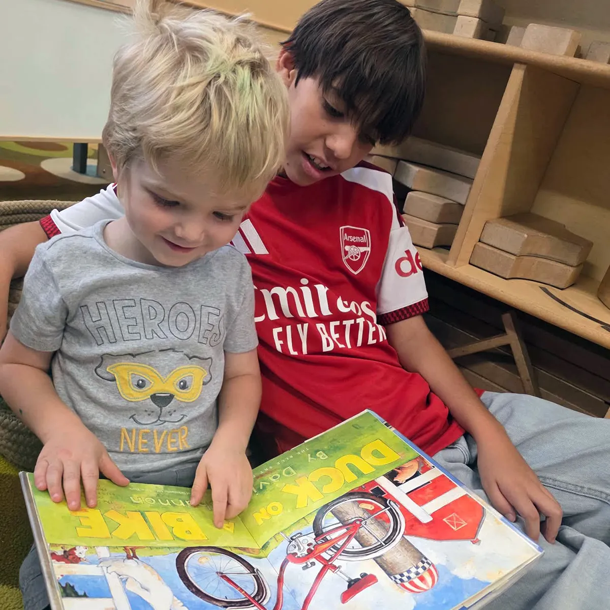 summit-school-older-student-reading-with-preschooler Older Summit School student reading a picture book with a preschool student.