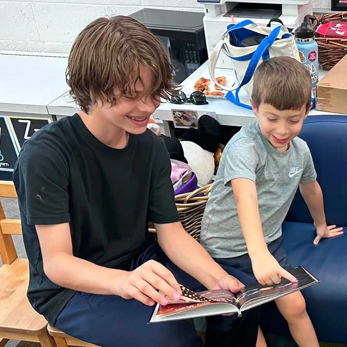 summit-serve-middle-school-mentoring-younger-student Summit middle school student reading with a younger student as part of the SERVE experience.