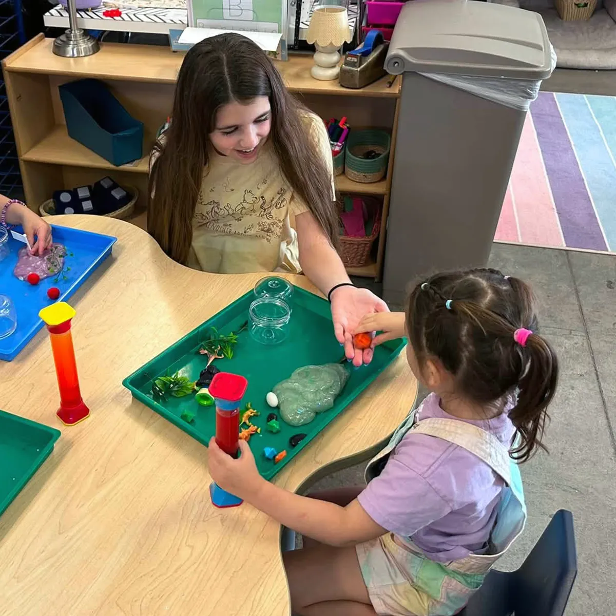 summit-serve-student-preschool-mentoring Summit middle school student helping a preschool student during a hands-on classroom activity.