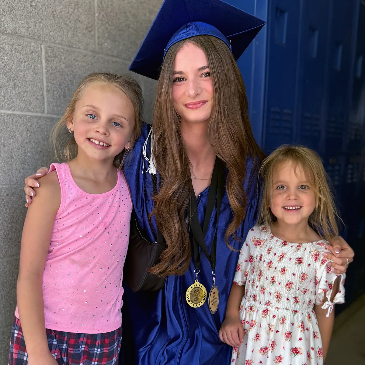 summit-student-leadership-graduation Summit graduate in cap and gown with two younger students, reflecting leadership and growth across the Summit community.