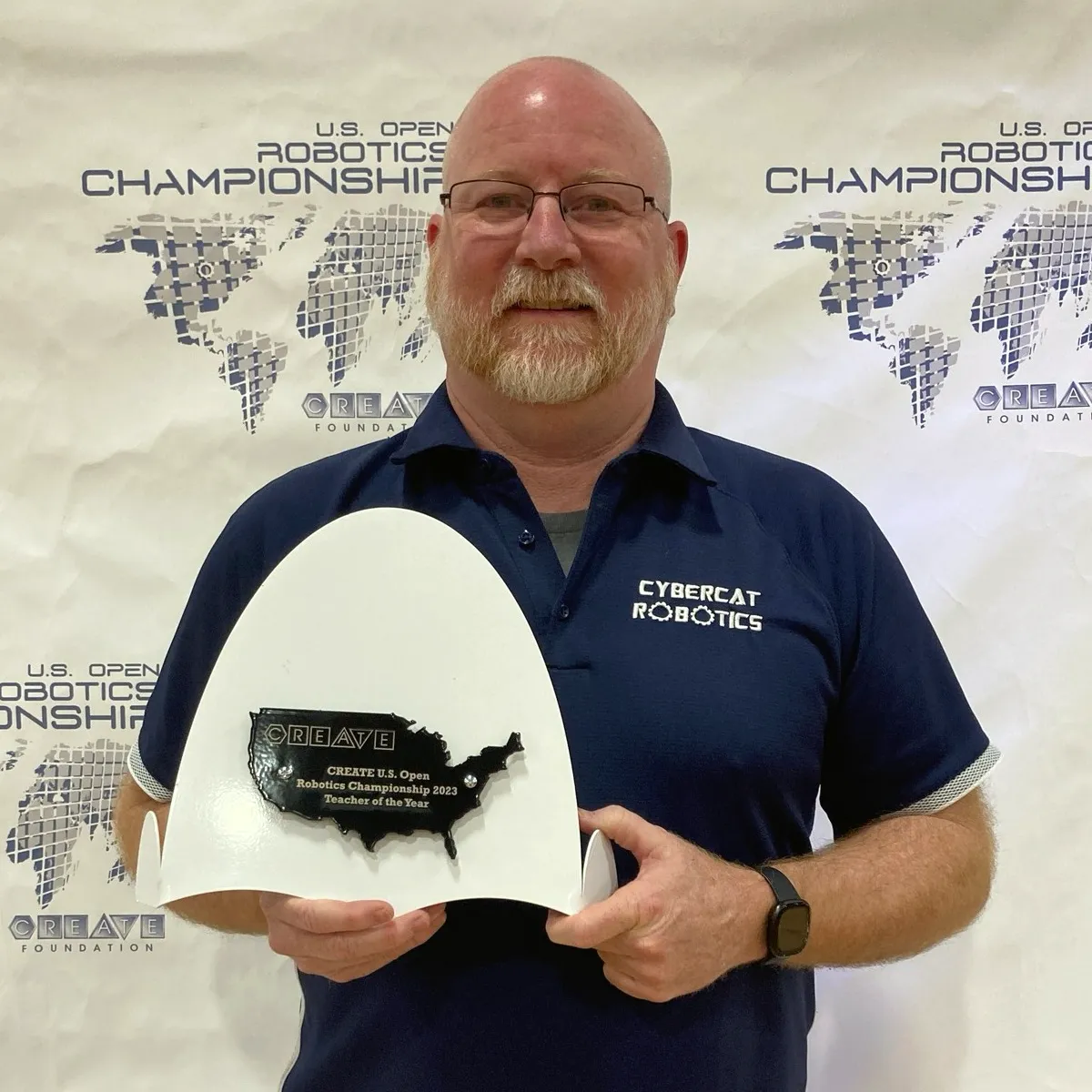Summit School Cybercat Robotics coach Jeremy Douwstra holding his 2023 CREATE U.S. Open Robotics Championship Teacher of the Year award.