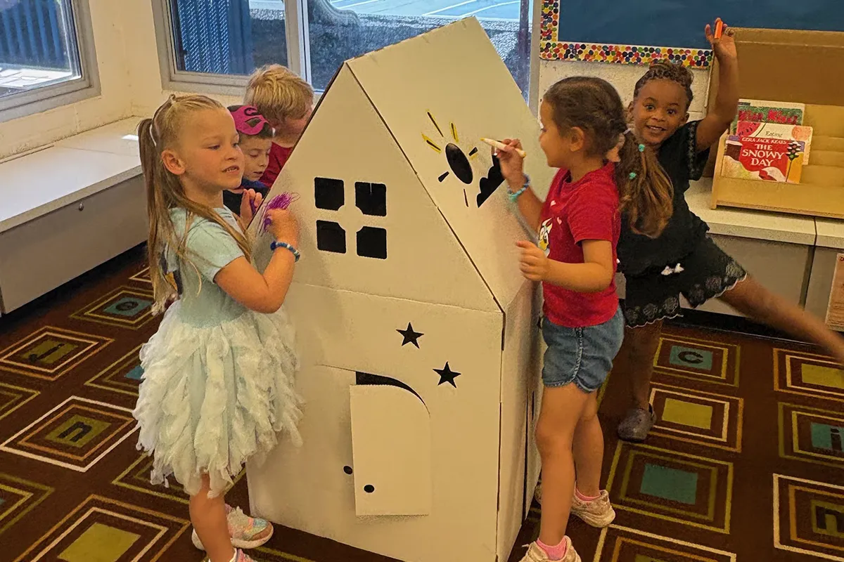 summit-school-time-with-friends-extended-day Young students spending time with friends while decorating a cardboard playhouse at Summit School.